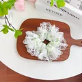 Detailed view of large green polka dot lace scrunchie on an elegant wooden tray - Lace Scrunchie