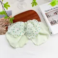 Details einer hellgrünen floralen Haarschleife mit Perle auf einem Holztablett - Doppellagige Schleife