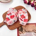 Lazo para el pelo con flores rojas y perla sobre soporte de madera rústico - Lazo de Perlas