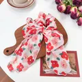 Blumiges Chiffon Haargummi mit langen Bändern und rotem Blumenmuster auf Holzbrett - Einlagige Bandschleife