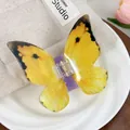 Vue macro d'une grande pince à cheveux papillon jaune avec ressort métallique durable - Jaune Irisé