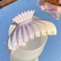 Primer plano de la pinza para el pelo de concha nacarada sobre una taza de porcelana - Cola-de-pez-2 (Degradado Amarillo Rosa Púrpura Irisado)