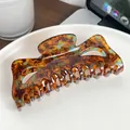 Oversized tortoise shell hair claw clip with amber and blue acetate marble pattern - Caramel color