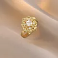Elegant gold flower ring featuring a square crystal center on satin background - Vintage Hollow Floral Square Stone Style (J1193)