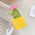 Close-up of a cute green cactus hair clip with pink flower on a white metal basket - Yellow Cactus