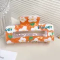 Oranje marmeren acetaat haarklem met bloemenprint en de tekst Flower erop - Oranje