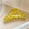 Gros plan détaillé d'une pince à cheveux jaune avec motifs de canards et dents solides - Demi-lune