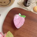 Top view of a pink peach-shaped hair claw clip with a glossy pearlescent finish - Peach