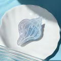 Macro detail of a translucent sea shell hair claw with blue and purple gradient effects - Conch