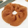 Brown knit scrunchie with white pearl accents on a clean white textured background - Orange Pearl
