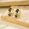 Detail of gold hoop earrings with black enamel and pink daisy floral pattern - Hoop Huggie (1 Pair) / Gold Base Black Enamel Floral (EH5456-2)