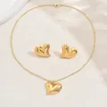Macro view of gold heart jewelry set including polished necklace and stud earrings - 3D Twisted Heart Style (XL5729)