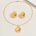 Detailed close-up of gold polished oval pendant necklace and matching stud earrings set - Mirror Polished Oval Style (XL5737)
