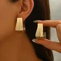 Elegant gold U-shaped ribbed earrings with vertical striped texture shown on a model - U-Shape Striped Grid Gold Earrings (EH5232)
