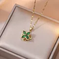 Elegante goldene Kleeblatt-Halskette mit grünen Zirkonia-Steinen und Kristallakzenten - Halskette / Smaragdgrün/Gold
