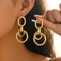 Boucles d'oreilles créoles dorées multicouches ajourées portées par un mannequin - Grandes Boucles d'Oreilles Créoles Imbriquées Or (EH5505)