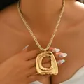 Detailed close-up of a large textured gold abstract pendant with a twisted rope chain - Gold Style (XL5868)