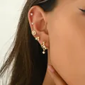Detailopname van gouden ster- en maan-oorstekers met zirkonia steentjes op het oor - Ster Maan Stijl (EH4984)