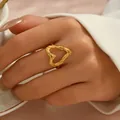 Elegant gold heart ring with hammered texture on a female finger in a lifestyle shot - Hollow Lava Texture Heart Style (JZ1312-8)