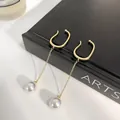 Elegant gold chain ear cuff with white pearls for non-pierced ears shown on a book - Gold Chain Pearl