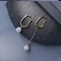 Ear cuff dorati con perle e nappa a catena asimmetrica su sfondo di pietra scura - Oro Catena Asimmetrica