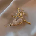 Exquisite golden reindeer brooch with sparkling cubic zirconia on soft satin backdrop - Zircon Reindeer Style / Gold