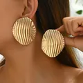 Women's 18k gold plated geometric earrings with textured wavy surface on model - Wave Stripe Large Disc Style (EH4739-2)