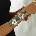 Ensemble de bracelets argentés avec pierres vertes et motifs floraux portés par mannequin - Ensemble Joncs Argentés Mat Floral Pierre Verte (SLSF819-3)