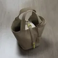 Minimalist PU leather bucket bag with top handles and a canvas inner pouch in taupe finish - Gray