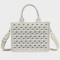 Detailed view of beige PU tote bag featuring rows of silver round metal rivets and strap - Studded White