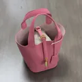 Top view of bright pink textured PU leather bucket bag with inner organizer and gold lock - Rose Red