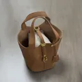 Top view of brown lychee grain PU bucket bag with gold lock and herringbone fabric liner - Brown