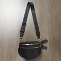 Close-up of black nylon shoulder bag with dual gold zippers and adjustable strap - Solid Black