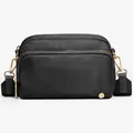Close-up of black nylon crossbody bag with premium gold-tone zippers and adjustable strap - Black