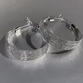Dettaglio ravvicinato di orecchini a cerchio in argento con texture a rete fitta - Cerchio Multistrato - Oro