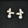 Dettaglio macro di orecchini a farfalla con perle, cornice dorata e cristalli - Stile Farfalla con Perla Artificiale (D0668) / Oro