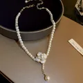 Dettaglio del ciondolo a camelia con piccole perle bianche e catena di estensione dorata - Fiore Grande Perla (L0191)