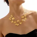 Dettaglio della collana dorata con foglie dalle venature naturali e finitura in metallo spazzolato - Stile Foglia / Oro
