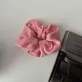 Pink plush scrunchie made of soft towel fabric with a small silver metal logo charm - Pink