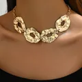 Irregular gold necklace with lava texture metal plates shown on a fashion model - Gold Irregular Hammered Style (XL5382)