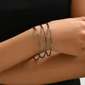 Vista dettagliata di tre braccialetti neri testurizzati sul polso di una donna - Stile Canna di Fucile (SL7574-4) / Set di 3 / Canna di fucile