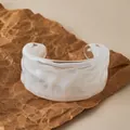 Detailed view of wide irregular marble texture acrylic bangle on a neutral paper backdrop - White Marble Texture (AB0085-1)