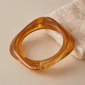 Close-up of square amber resin bracelet with tortoise texture on stone surface - Tortoise Brown (AB0086-4)