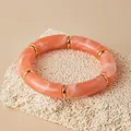 Dettaglio del bracciale in resina marmorizzata rosa con anelli dorati su pietra - Rosa Arancio Marmorizzato (AB0079-9)