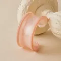 Detail view of pink acrylic cuff bracelet with marble texture on stone stand - Pink Orange Style (AB0090-2)