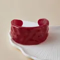 Gros plan d'un bracelet manchette en acrylique rouge translucide à texture ondulée - Rouge Foncé (AB0085-8)