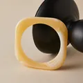 Macro detail of amber resin square bangle with white marble texture on black stand - Bright Yellow (AB0086-6)