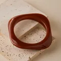 Detail of reddish-brown irregular square resin bangle on a beige stone surface - Reddish Brown (AB0086-9)