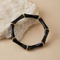 Detalle de pulsera elástica estilo bambú con cuentas de resina veteada negra y dorada - Mármol Negro