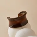 Detail of amber brown acrylic cuff bracelet with marble texture on minimalist stand - Deep Brown Amber Pattern Style (AB0090-11)